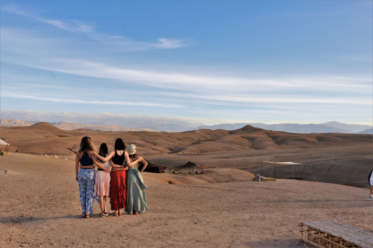 Four women in the desert holding each other